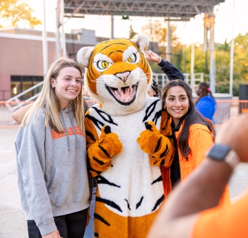 Bengal with three students having a picture taken.