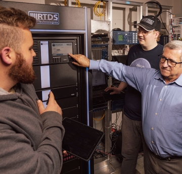 Professor pointing at a display panel