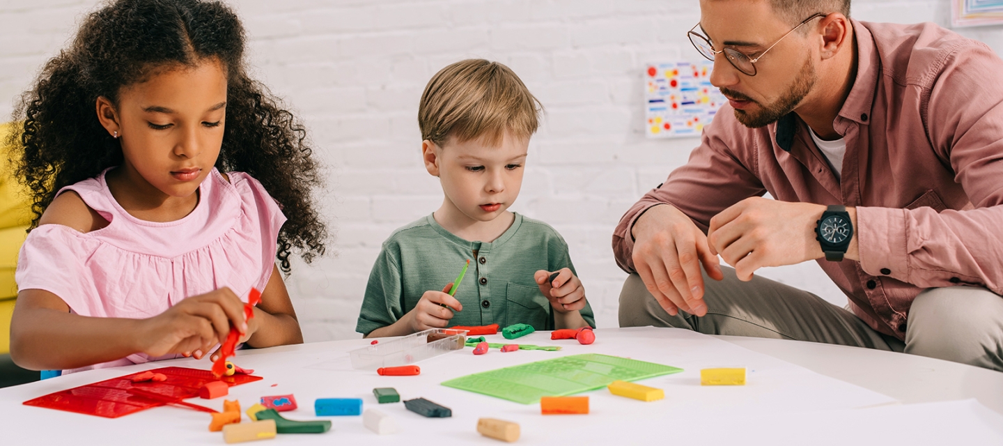 Students and a teacher playing with clay 